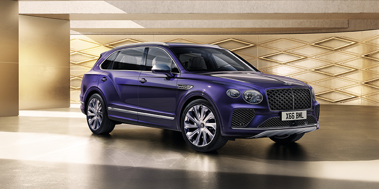 Bentley Padova Bentley Bentayga Extended Wheelbase Mulliner SUV front three quarter in Tanzanite Purple paint with a gold patterned background