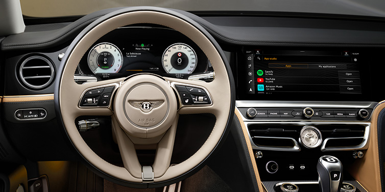 Bentley Padova Bentley Flying Spur Mulliner sedan front interior detail of steering wheel and driver screens surrounded by Linen and Beluga black hides