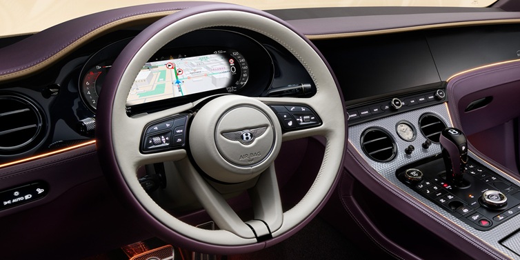 Bentley Padova Bentley Continental GT Mulliner coupe front interior showing steering wheel and drivers screens surrounded by Linen and Damson hides and Grand Black veneer